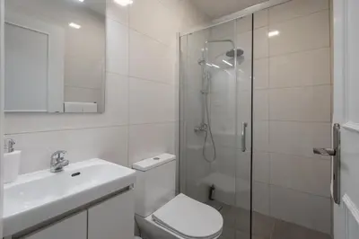 a bedroom with a bed and a toilet and a window at Terrace Vila II by An Island Apart in Santa Cruz