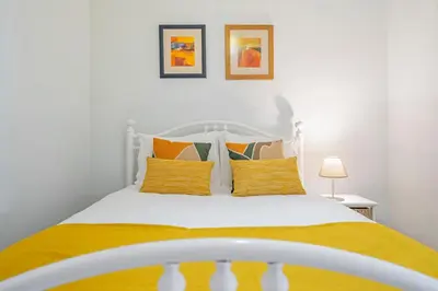 a bedroom with a white bed with yellow pillows at Terrace Vila II by An Island Apart in Santa Cruz