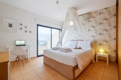 a bedroom with a bed with a mosquito net at Casa das Pedras Pretas - By WeHost in Porto Santo