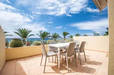 a table and chairs on a balcony with a view of the ocean at Casa das Pedras Pretas - By WeHost in Porto Santo