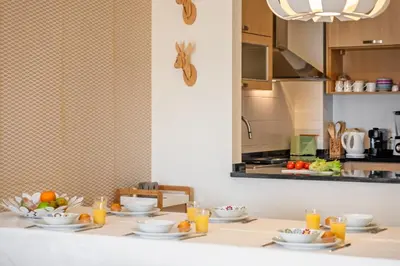 a table with plates of food and glasses of orange juice at Casa das Pedras Pretas - By WeHost in Porto Santo