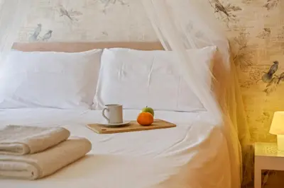 a tray with an apple and an orange on a bed at Casa das Pedras Pretas - By WeHost in Porto Santo