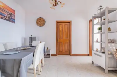 a dining room with a table and white walls at The Balcony - By Wehost in Santa Cruz
