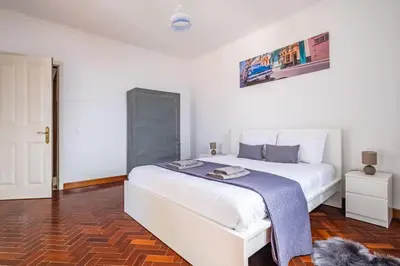 a bedroom with a large white bed with a blue blanket at The Balcony - By Wehost in Santa Cruz