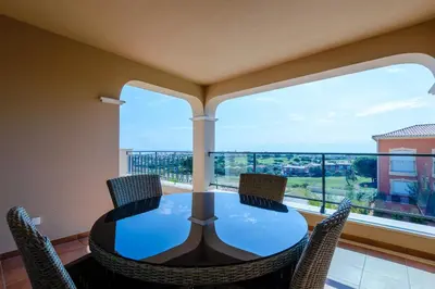 a dining room with a table and chairs and a large window at Boavista Golf and Spa Resort - Bayview in Lagos
