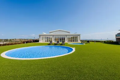 a house with a pool in the middle of a grass field at Boavista Golf and Spa Resort - Bayview in Lagos