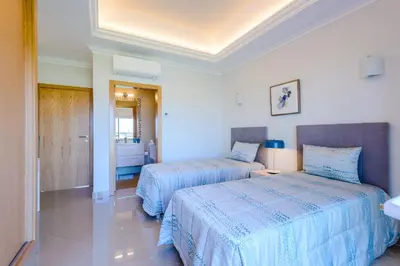 a bedroom with two beds and a bathroom at Boavista Golf and Spa Resort - Bayview in Lagos
