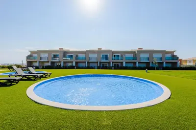 a swimming pool in front of a building at Boavista Golf and Spa Resort - Bayview in Lagos