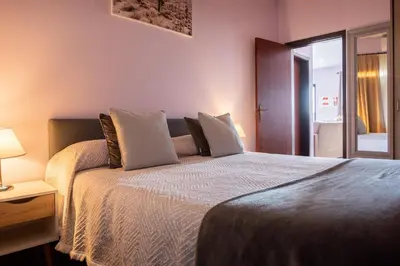 a bedroom with a bed with white sheets and pillows at Village Center Two Bedroom Apartment in Porto Moniz