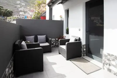 a patio with two chairs on a balcony at Village Center Two Bedroom Apartment in Porto Moniz