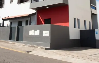 a building with a red and white wall and a street at Village Center Two Bedroom Apartment in Porto Moniz