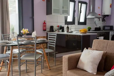 a kitchen and living room with a table and chairs at Village Center Two Bedroom Apartment in Porto Moniz