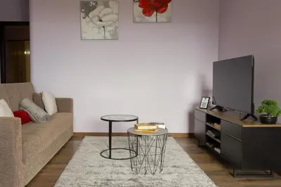 a living room with a couch and a tv and a table at Village Center Two Bedroom Apartment in Porto Moniz