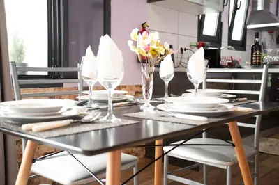 a dining room table with plates and glasses on it at Village Center Two Bedroom Apartment in Porto Moniz