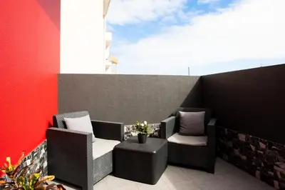 a balcony with two chairs and a table at Village Center One Bedroom Apartment in Porto Moniz