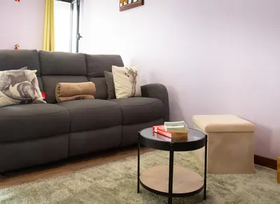 a living room with a couch and a table at Village Center One Bedroom Apartment in Porto Moniz