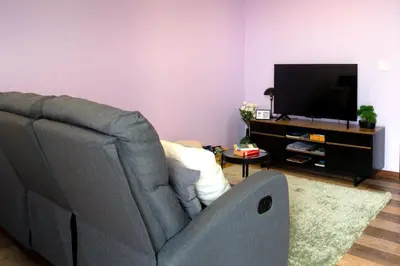 a living room with a couch and a flat screen tv at Village Center One Bedroom Apartment in Porto Moniz