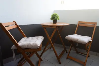two chairs and a table with a potted plant on it at Village Center One Bedroom Apartment in Porto Moniz