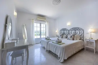 a white bedroom with a large bed and a desk at CoolHouses Algarve Lagos, 4 bed single-story House, pool and amazing panoramic views, Casa Fernanda in Lagos