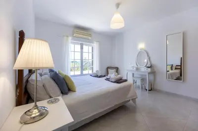a bedroom with a bed with a lamp and a mirror at CoolHouses Algarve Lagos, 4 bed single-story House, pool and amazing panoramic views, Casa Fernanda in Lagos