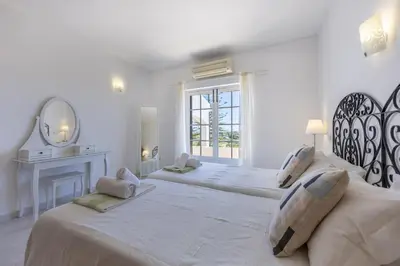 a white bedroom with two beds and a mirror at CoolHouses Algarve Lagos, 4 bed single-story House, pool and amazing panoramic views, Casa Fernanda in Lagos