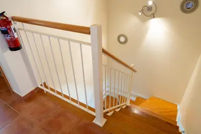 a staircase with a white rail and wooden floors at Vista Mar in Porto Santo