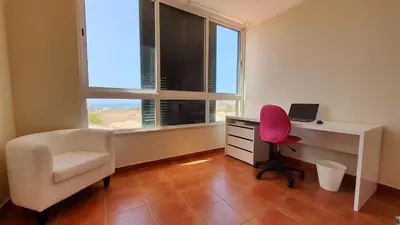 a room with a desk and a chair and a desk with a computer at Vista Mar in Porto Santo