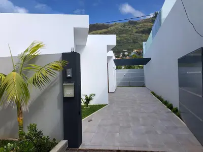 a hallway of a white house with a palm tree at Noah - Private Sunset Hideaway by LovelyStay in Arco da Calheta