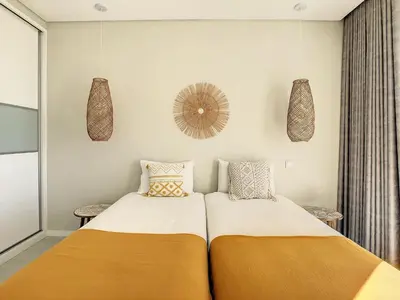 a bedroom with two beds and a mirror on the wall at Noah - Private Sunset Hideaway by LovelyStay in Arco da Calheta