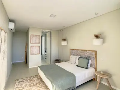 a bedroom with a large bed and a table at Noah - Private Sunset Hideaway by LovelyStay in Arco da Calheta
