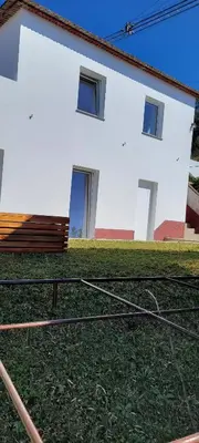 a white building with a grass yard and a house at House Nobrega of Madeira in Arco da Calheta