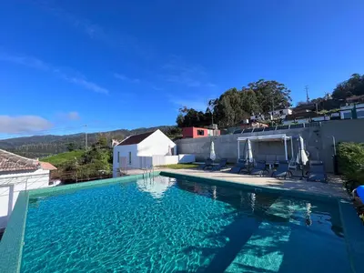a large swimming pool with blue water on top of a building at House Nobrega of Madeira in Arco da Calheta