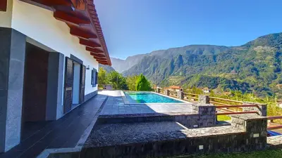 a house with a swimming pool and mountains in the background at Quinta do Conde by LovelyStay in Boaventura