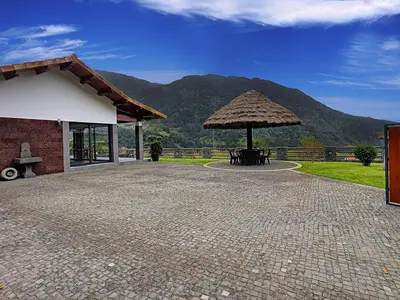 a patio with a table and a straw umbrella at Quinta do Conde by LovelyStay in Boaventura