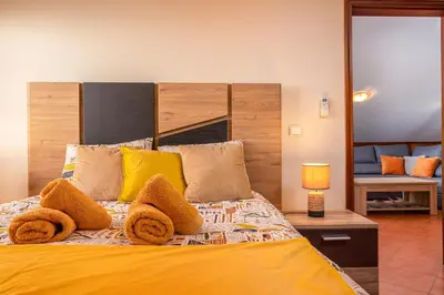 a bedroom with a large bed with yellow pillows at CASA POR DO SOL in Calheta