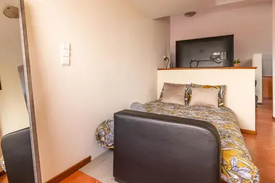 a small bedroom with a bed and a tv at CASA POR DO SOL in Calheta