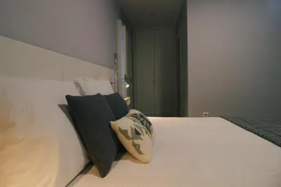 a bedroom with a white bed with a pillow on it at Casa do Brasileiro in Arco da Calheta
