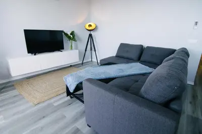 a living room with a couch and a flat screen tv at Casa do Brasileiro in Arco da Calheta