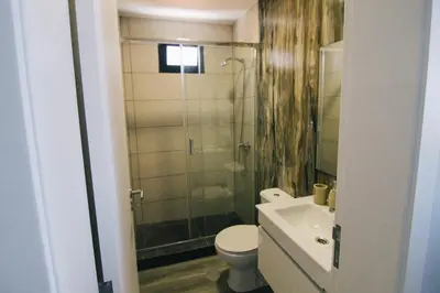 a bathroom with a shower and a toilet and a sink at Casa do Brasileiro in Arco da Calheta