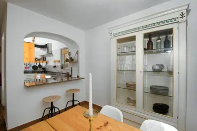 a dining room with a table and a cabinet with dishes at 205 Casa Cactus in Sagres