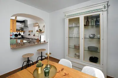 a dining room with a table and a cabinet filled with dishes at 205 Casa Cactus in Sagres