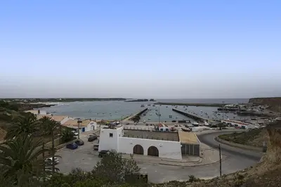a small white building next to a body of water at 205 Casa Cactus in Sagres