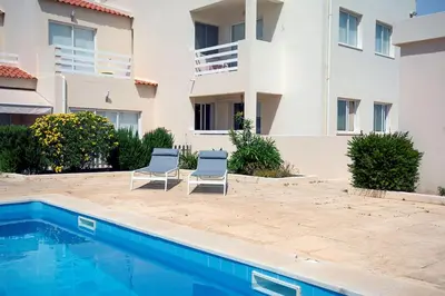two chairs and a swimming pool in front of a building at 205 Casa Cactus in Sagres