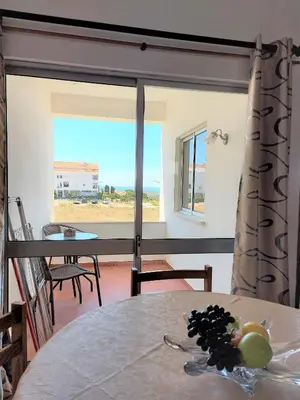 a dining room with a table and a view of the ocean at Apartamento vista mar e pôr do Sol (1,6km Praia) in Aljezur