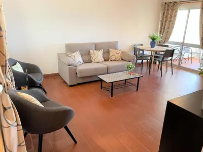 a living room with two chairs and a curtain at Apartamento vista mar e pôr do Sol (1,6km Praia) in Aljezur