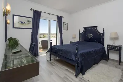 a bedroom with a blue bed and a window at 607 Villa Lorena in Lagos