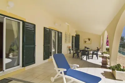 a blue chair on a balcony with a table and chairs at 607 Villa Lorena in Lagos