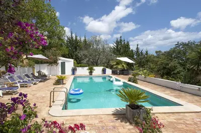 a swimming pool in a yard with chairs and flowers at 607 Villa Lorena in Lagos