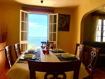 a balcony with two chairs and an umbrella at Casa Neves three bedrooms and fantastic sea view in Arco da Calheta