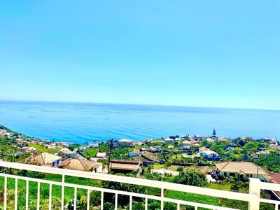 a living room with a tv and a table at Casa Neves three bedrooms and fantastic sea view in Arco da Calheta